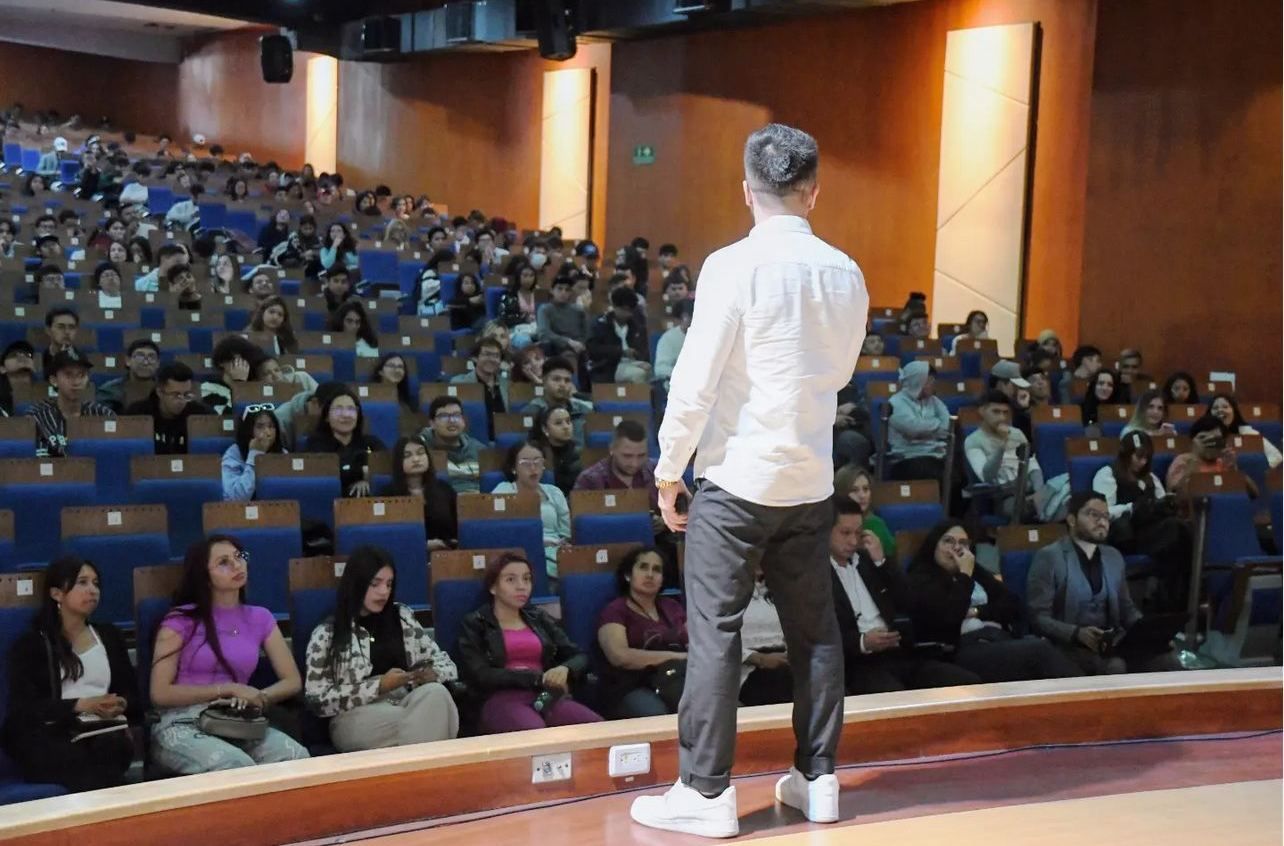 Abel Loaiza dando una conferencia ante un auditorio lleno